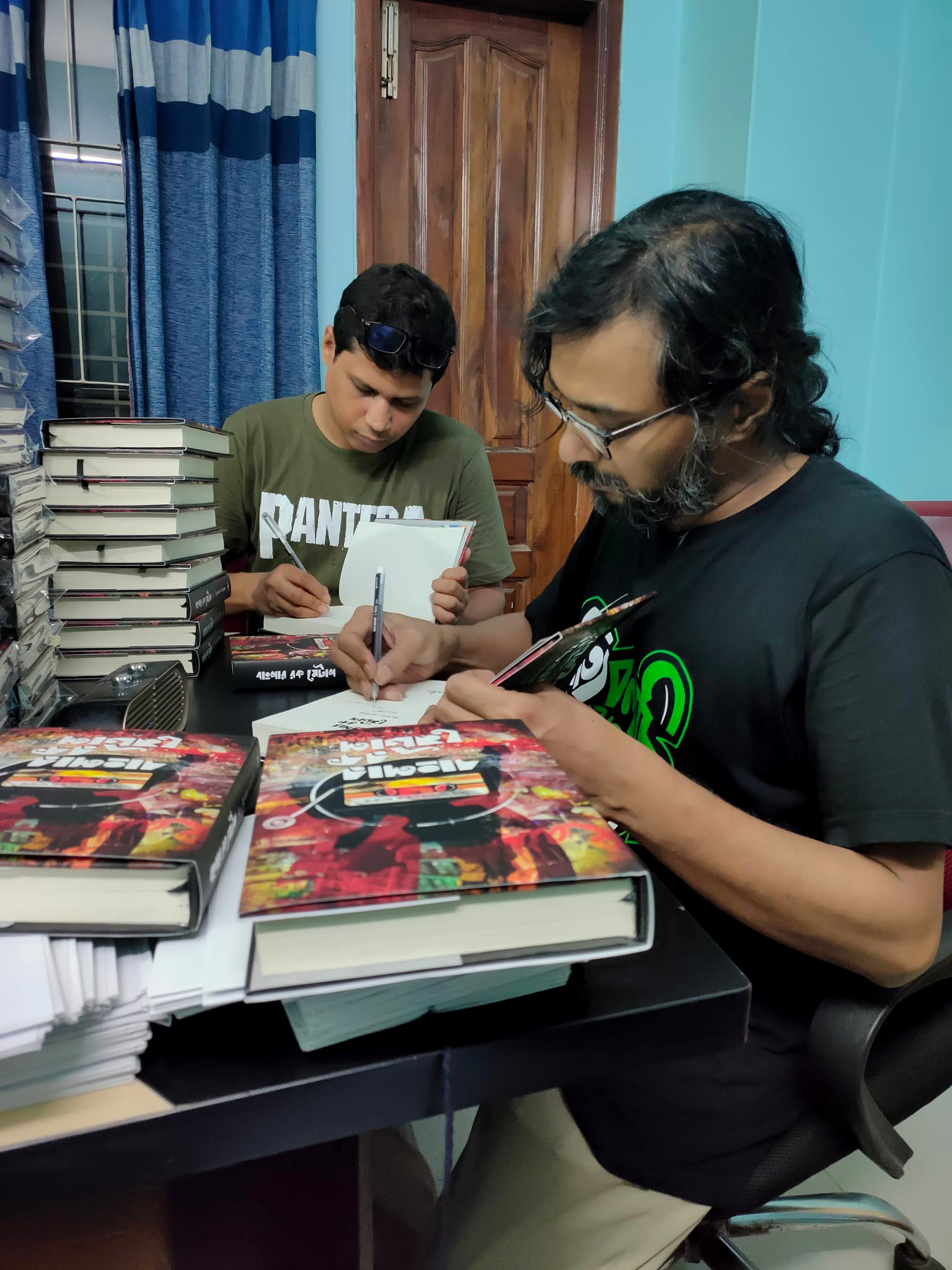 Writers of Banglar Rock Metal book, Haque Faruk and Milu Aman, signing pre-ordered books